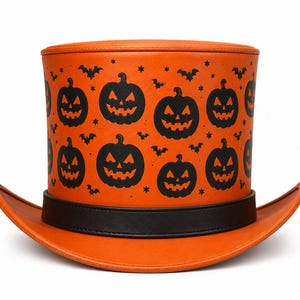 Puede incluir: Un sombrero de copa naranja con un patrón negro repetitivo de calabazas de Halloween, murciélagos y pequeñas estrellas. El sombrero tiene una parte superior plana, un ala ancha y curva, y una banda negra sólida que rodea la base de la copa.