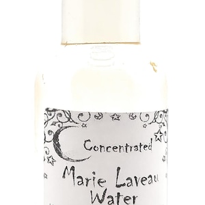May include: A clear glass bottle with a black cap, labeled "Concentrated Marie Laveau Water." The label includes text about increasing psychic powers and spiritual cleansing. The bottle contains 1.7 oz of liquid.