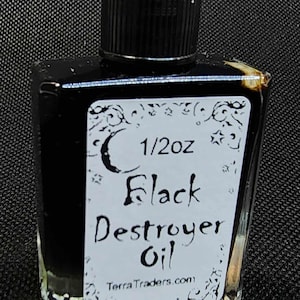 Peut inclure: Petite bouteille carrée en verre remplie de liquide noir, coiffée d'un bouchon noir. L'étiquette indique "1/2 oz Black Destroyer Oil" avec des éléments décoratifs et le site TerraTraders.com.
