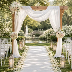 May include: Wedding ceremony setting with a wooden archway draped in white fabric. Floral arrangements of white and pink flowers decorate the arch. A white aisle runner is lined with flower petals, leading to a pond and bridge in the background.