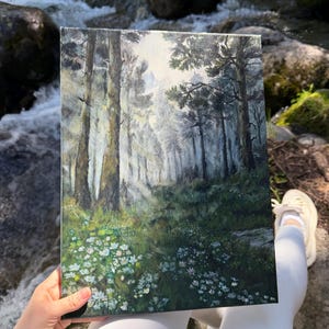 Op de afbeelding: Een rechthoekig canvas schilderij toont een mistige bosscène. Hoge, slanke bomen domineren de compositie, met een pad dat in de verte leidt. De voorgrond toont witte en groene wilde bloemen. Het kleurenpalet omvat groen, bruin en wit.