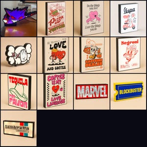 Può includere: Una collezione di tredici scatole luminose a LED rettangolari e sagomate con vari design grafici, inclusi personaggi della cultura pop, temi legati alle bevande e arte testuale con colori vivaci e cornici nere per esposizione.