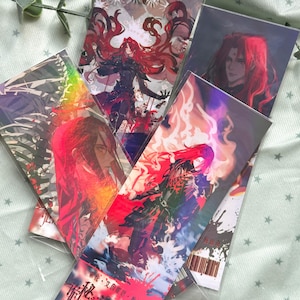 May include: A collection of rectangular art prints featuring anime-style characters with long red hair. The illustrations display vibrant colors, dynamic poses, and intricate details, including flowing garments, fiery effects, and dark, skeletal motifs.