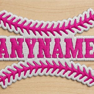 May include: An embroidered patch featuring the word ANYNAME in bold, hot pink capital letters. The text is centered between two curved, white, and hot pink baseball-style stitch patterns that mimic the look of a softball or baseball seam.