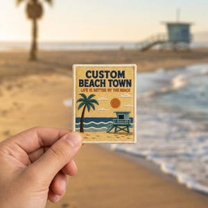 May include: A rectangular embroidered patch featuring a tan background with a palm tree, a lifeguard tower, and a sun. The text reads CUSTOM BEACH TOWN and LIFE IS BETTER BY THE BEACH in dark blue and orange lettering, with a stitched border.