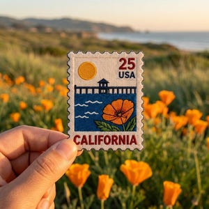 May include: A rectangular embroidered patch shaped like a postage stamp featuring a yellow sun, a dark blue pier, and an orange California poppy flower. The text reads 25 USA and CALIFORNIA in dark red lettering on a cream-colored background.