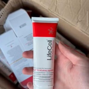 May include: A white and red squeeze tube of LifeCell South Beach Skincare All-In-One Anti-Aging Treatment. The tube features a red band at the top, the brand name LifeCell, and text detailing its use as an anti-wrinkle and firming treatment.
