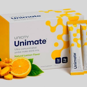 May include: A white and yellow box of Unicity Unimate ultra-concentrated yerba mate drink mix with natural lemon flavor, accompanied by two matching single-serve packets, fresh ginger root, and a sliced lemon with green leaves on the side.