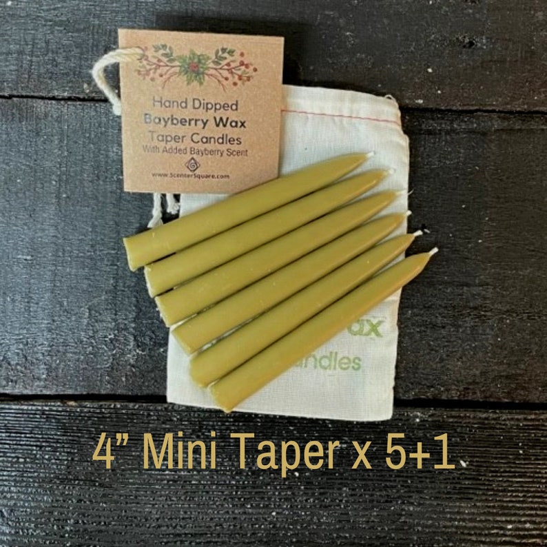 May include: A set of six 4-inch mini taper candles in a natural beige colour, packaged in a white muslin bag with a brown paper tag that reads "Hand Dipped Bayberry Wax Taper Candles With Added Bayberry Scent" and a website address. The bag also has the words "Wax" and "Candles" printed on it. The text "4" Mini Taper x 5+1" is printed below the image.
