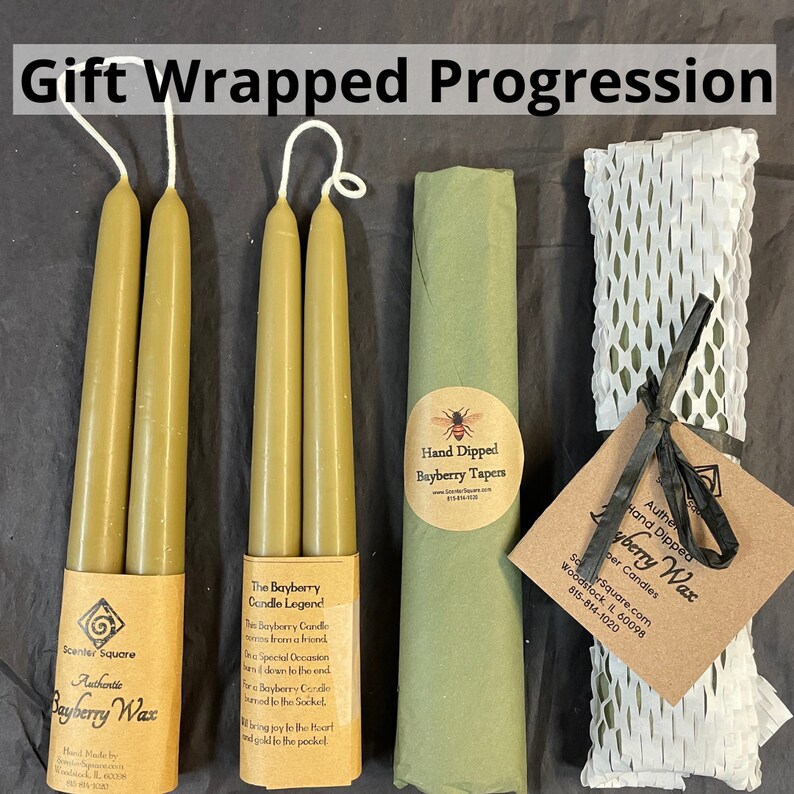May include: Three green Bayberry wax candles wrapped in brown paper with a label that reads "The Bayberry Candle Legend". The candles are next to a green paper-wrapped package with a label that reads "Hand Dipped Bayberry Tapers". The third package is wrapped in white bubble wrap and has a label that reads "Authentic Hand Dipped Bayberry Wax Candle".