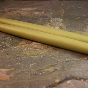 May include: Two green taper candles, approximately 10 inches long, with a white wick.