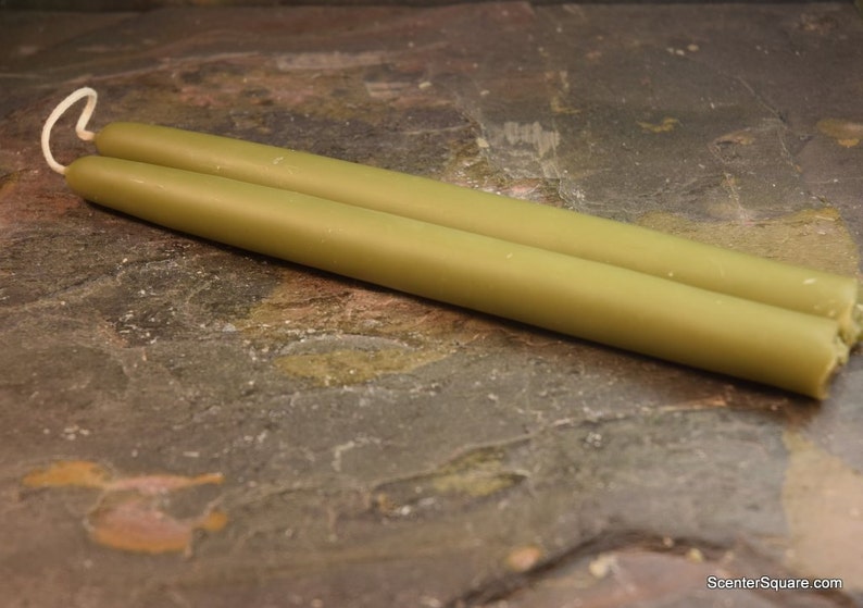 May include: Two green taper candles, approximately 10 inches long, with a white wick.