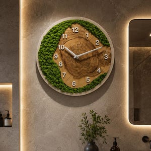 May include: A circular wall clock featuring a natural wood slice center with visible grain and rings, surrounded by a crescent of vibrant green preserved moss. The clock face includes white Arabic numerals from 1 to 12 and thin white hands.