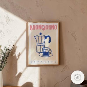 Può includere: Una stampa artistica incorniciata con un'illustrazione blu e bianca di una caffettiera e una tazza di espresso. Le parole "BUONGIORNO" in rosa e "ESPRESSO" in bianco sono stampate sull'opera d'arte.