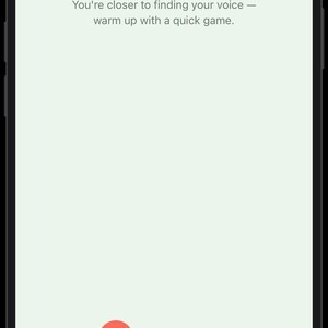 May include: A smartphone screen displaying a light green interface with the text Your program is ready! You're closer to finding your voice &mdash; warm up with a quick game. Below is a dark grey button labelled Play a game and a Skip game link.