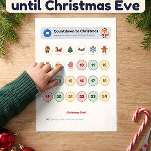 A child's hand covers day 8 on the Countdown to Christmas page of the busy book