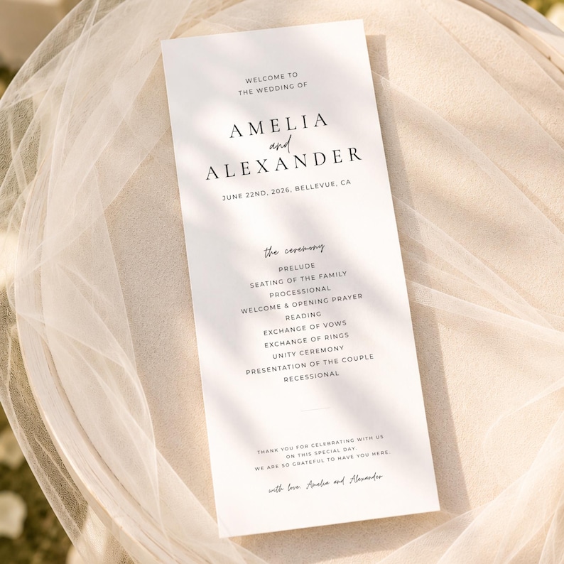 Puede incluir: Un programa de boda blanco con texto negro, con los nombres Amelia y Alexander, y la fecha 22 de junio de 2026. El programa enumera los eventos de la ceremonia, incluyendo preludio, votos y ceremonia de la unidad. El programa est&aacute; sobre una tela blanca y transparente.