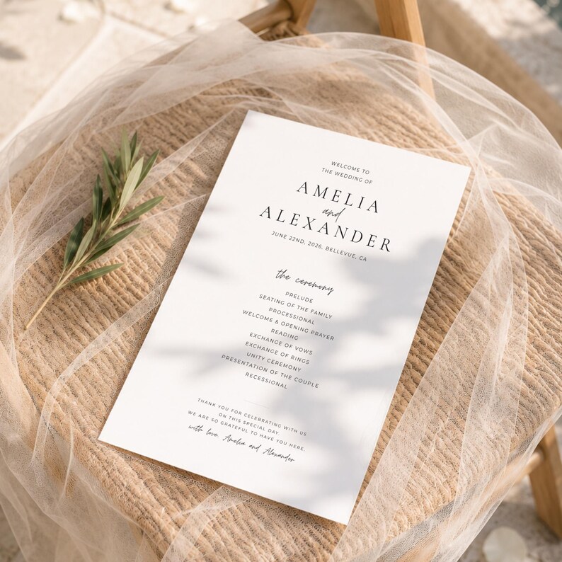Puede incluir: Un programa de boda blanco con texto negro, con los nombres "Amelia y Alexander" y la fecha de la boda. El programa enumera el orden de la ceremonia, incluyendo preludio, lecturas y votos. Descansa sobre una silla tejida con una gasa blanca.