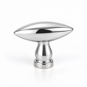 May include: A polished chrome cabinet knob featuring a horizontal, elongated, almond-shaped handle mounted on a rounded, pedestal-style base. The metallic surface is highly reflective, showing smooth, curved contours and a bright, silver-toned finish.