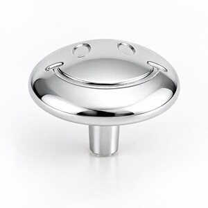 May include: A polished silver-toned metal cabinet knob featuring a circular, domed face with an embossed smiley face design. The knob has a smooth, reflective surface and a cylindrical base, designed for attachment to furniture or cabinetry doors.