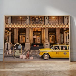 May include: A framed wall art print depicting a yellow taxi cab parked in front of a grand hotel entrance with stone columns. Several dogs are positioned near a gold luggage cart and pink suitcases on a checkered floor under a decorative canopy.