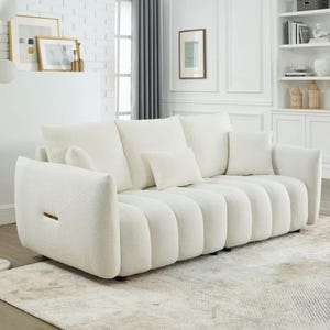 Puede incluir: Un sof&aacute; grande, de color blanco roto, con un dise&ntilde;o redondeado &uacute;nico. El sof&aacute; tiene m&uacute;ltiples cojines y una tela texturizada. Los brazos tienen una forma distintiva y la pieza se asienta sobre una alfombra de color neutro. Los cojines decorativos a&ntilde;aden comodidad.