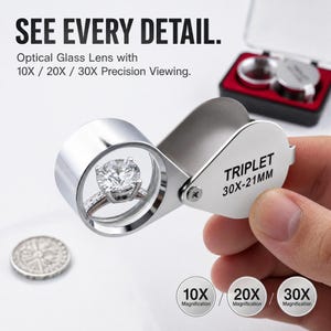May include: A silver-coloured jeweller's loupe with a folding metal frame, labelled TRIPLET 30X-21MM, magnifying a diamond ring. The text SEE EVERY DETAIL and Optical Glass Lens with 10X / 20X / 30X Precision Viewing is visible, along with three circular icons.