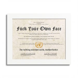 Pode incluir: Impressão emoldurada branca com o texto "fuck Your Own face" em uma fonte gótica. A impressão apresenta texto adicional com um emblema das Nações Unidas e as frases "I'm talking scorched earth, motherfucker" e "I will massacre you".