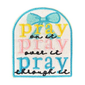 May include: Embroidered patch with a light blue border and a bow at the top. The patch features the words "Pray on it, Pray over it, Pray through it" in yellow, pink, and blue lettering.