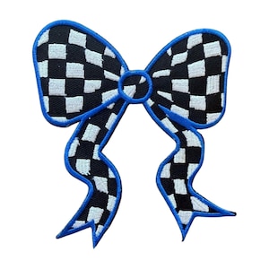 May include: A decorative bow-shaped patch with a checkered black and white pattern. The bow is outlined in bright blue, with a matching blue center. The patch is likely for clothing or accessories.