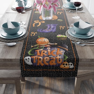 Può includere: Un runner da tavola nero a tema Halloween con zucche arancioni, stivali viola, fantasmi e fiocchi. Il centro mostra un grande cartello viola con la scritta arancione Trick or Treat, accentuato da un cappello da strega e viticci verdi.