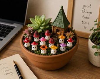 May include: A terracotta pot containing a miniature fairy garden. The garden includes colourful mushroom figurines, a small green house, and a succulent plant. A notepad and pen are in the foreground.