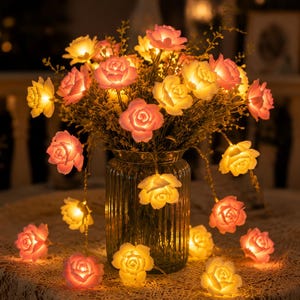 Könnte beinhalten: Eine dekorative Lichterkette mit LED-Rosen in Rosa und Gelb. Die Lichter sind in einer Vase mit einem Blumenstrauß angeordnet und schaffen eine warme, einladende Atmosphäre. Die Rosenlichter sind perfekt für die Inneneinrichtung.