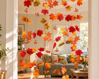 May include: A hanging room divider featuring multiple vertical strands of artificial maple leaves in shades of red, orange, and yellow. The strands are interspersed with small clusters of orange berries, creating a seasonal autumn display.