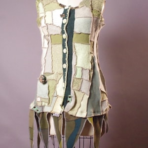 May include: A white ceramic mug with a black handle and the text "But First, Coffee" in a black, handwritten-style font. The mug is on a white surface.