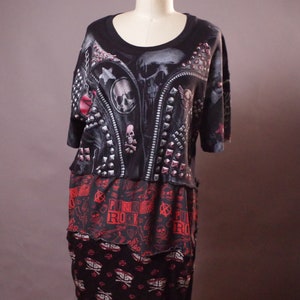 May include: Black and red punk rock themed t-shirt dress with a skull and crossbones print and a leather jacket design. The dress has a layered look with a black and red skull print on the bottom layer.