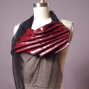 May include: A white ceramic mug with a black handle and the text "But First, Coffee" in a bold, black font. The mug is set against a blurred background, suggesting a cozy setting.