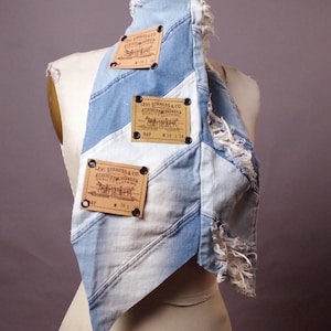 May include: A patchwork denim scarf with distressed edges and three brown Levi Strauss & Co. tags. The tags feature the brand's logo and size information. The scarf is displayed on a mannequin.