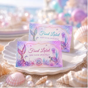 Puede incluir: Dos etiquetas de comida rectangulares de papel plegado con un tema de sirena en acuarela. El diseño incluye una cola de sirena, una tortuga marina, una perla en una concha y medusas en tonos morados, rosas y azules con el texto Food Label.