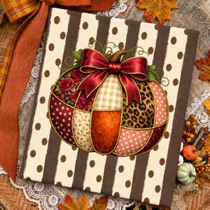 May include: A square decorative sign featuring a central pumpkin illustration composed of various patterned patches including roses, leopard print, gingham, and polka dots, topped with a large red satin bow, set against a brown and cream striped background.