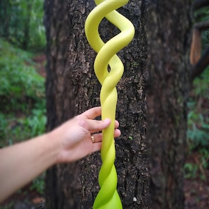 May include: A long, lime green object featuring a twisted, double-helix design that transitions into a single spiraled shaft, ending in a pointed, teardrop-shaped base. The surface has a smooth, matte finish with a vibrant, solid color throughout.