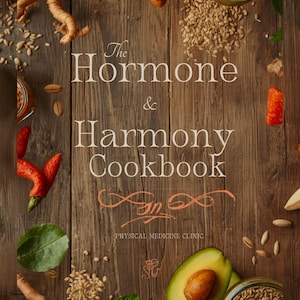 Pode incluir: A capa de "The Hormone & Harmony Cookbook" apresenta um fundo de madeira rústica com texto e vários ingredientes. O título do livro está em uma escrita elegante. Ingredientes como açafrão, abacate e sementes estão espalhados pela capa.