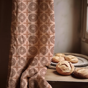 May include: A fabric curtain featuring a repeating geometric pattern in shades of terracotta and muted brown. The design consists of alternating circular motifs and cross-like shapes printed on a light peach background, hanging vertically.