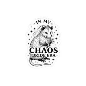 Op de afbeelding: Een zwart-witte sticker met een opossum met een bruidssluier en bloemen. De tekst "IN MY CHAOS BRIDE ERA" staat in vette letters, omringd door sterren.