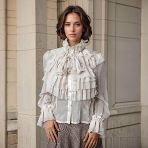May include: A long-sleeved, off-white blouse featuring a high ruffled collar, a prominent multi-layered ruffled bib front, and buttoned cuffs with ruffled edges. The blouse is made of a sheer, lightweight fabric and is paired with a brown plaid skirt.