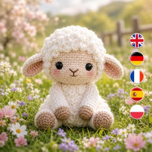 Könnte beinhalten: Ein gehäkeltes Stofftier in Form eines Lamms mit weißer, strukturierter Wolle, einem hellbeigen Gesicht, großen schwarzen Augen und rosa Wangen. Das Lamm hat Schlappohren und hellbraune Hufe und sitzt aufrecht mit einer weichen, runden Form.