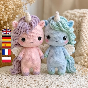 May include: Two crocheted unicorn dolls. One is pink with purple hair, the other is blue with mint green hair. Both have white wings, a white horn, and smiling faces. They are handmade and suitable for children.