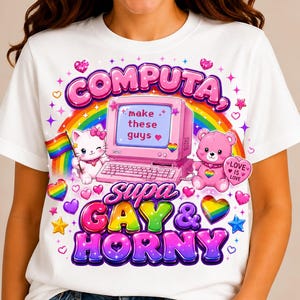 May include: A white t-shirt featuring a graphic print of a pink computer, a white kitten holding a rainbow flag, and a pink teddy bear. The text reads "COMPUTA, make these guys, supa GAY & HORNY" with rainbow hearts and stars surrounding them.