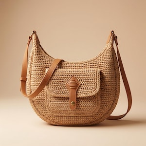 Può includere: Borsa a tracolla a forma di mezzaluna in paglia intrecciata. Presenta una tasca frontale con patta in pelle e una lunga tracolla regolabile in pelle. La borsa è di colore beige e marrone chiaro, su sfondo neutro.
