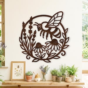May include: A circular dark brown wooden wall art piece featuring a laser-cut design of a bee hovering above two flowers and sprigs of lavender. The intricate cutout depicts the bee with striped details and wings, framed by a circular border.